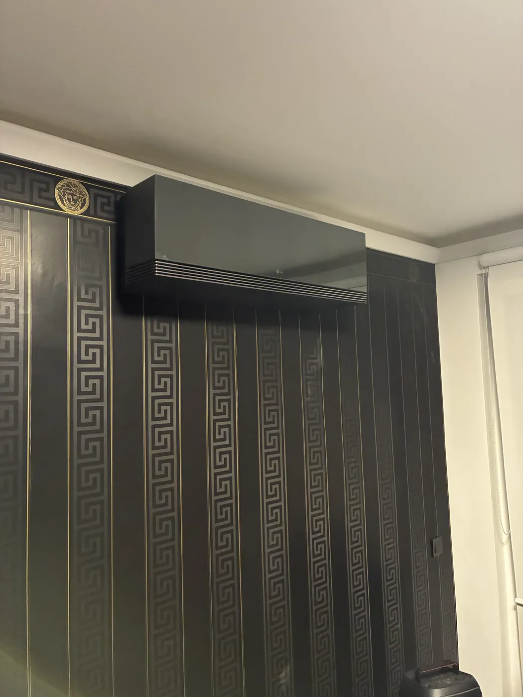 Schwarze LG ARTCOOL AI Air an einer dunklen Designtapete in einer Wiener Wohnung