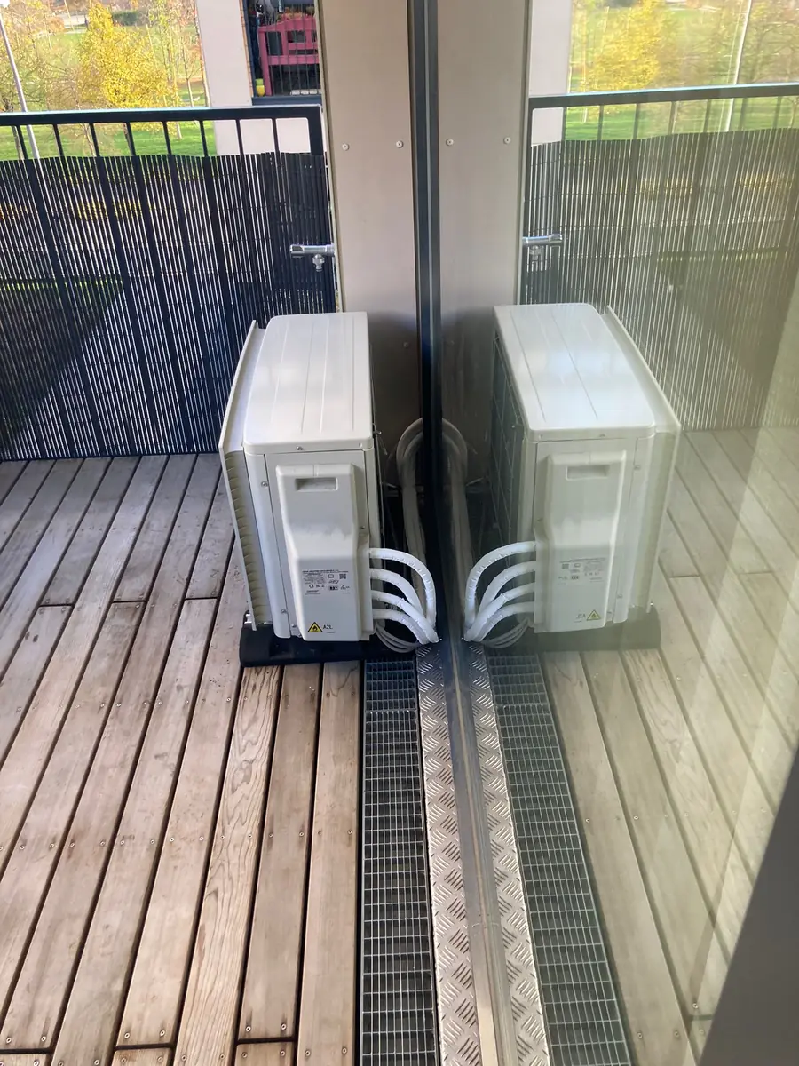 Multi-Split-Außengerät mit mehreren Leitungsanschlüssen auf einer Holzterrasse hinter dem Sichtschutz