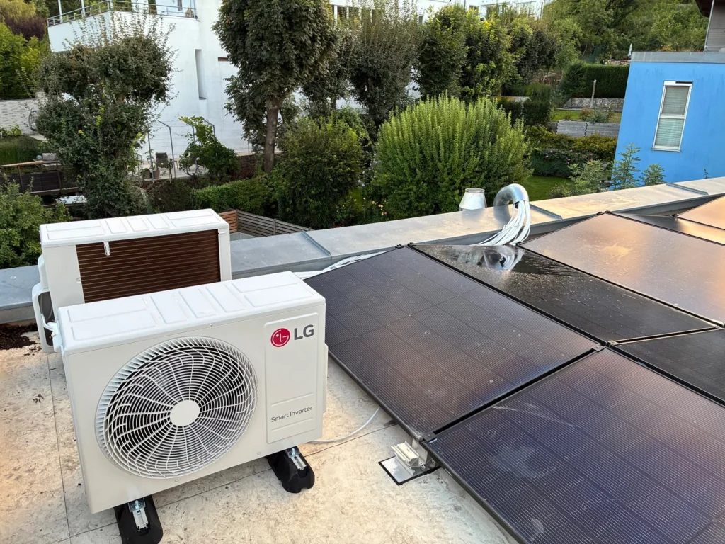 LG Außengerät einer Klimaanlage auf einem Flachdach neben Solarpaneelen